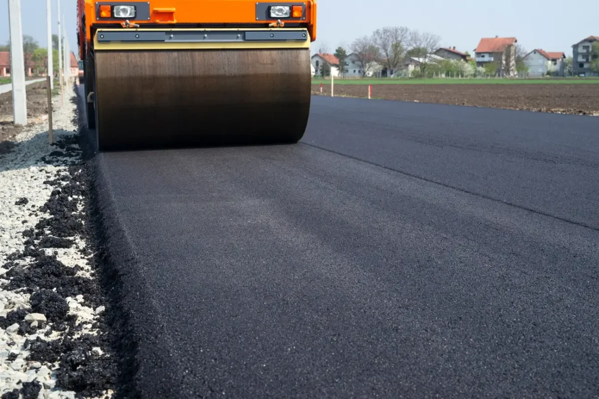 Built For Auckland Conditions by Asphalt Contractors Auckland showing a road roller compacting fresh asphalt for long lasting performance.