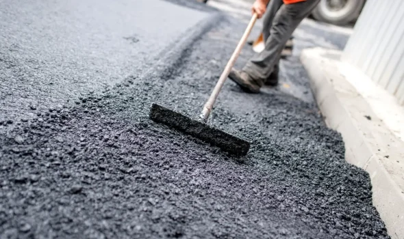 Specialist applying fresh asphalt during Asphalt Driveway Replacement North Shore service by Asphalt Contractors Auckland for tailored project solutions.
